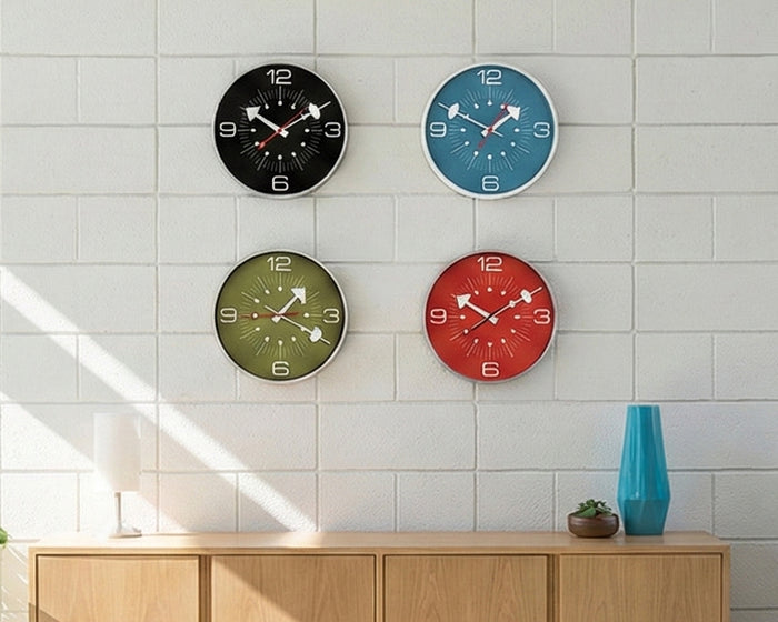 Four colorful wall clocks on a tiled wall with a wooden cabinet below.