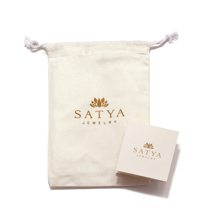 Satya Jewelry canvas bag and card, highlighting the brand's commitment to spiritual jewelry. The packaging reflects the essence of protection and meaning, suitable for talismans and malas used in yoga and meditation practices.