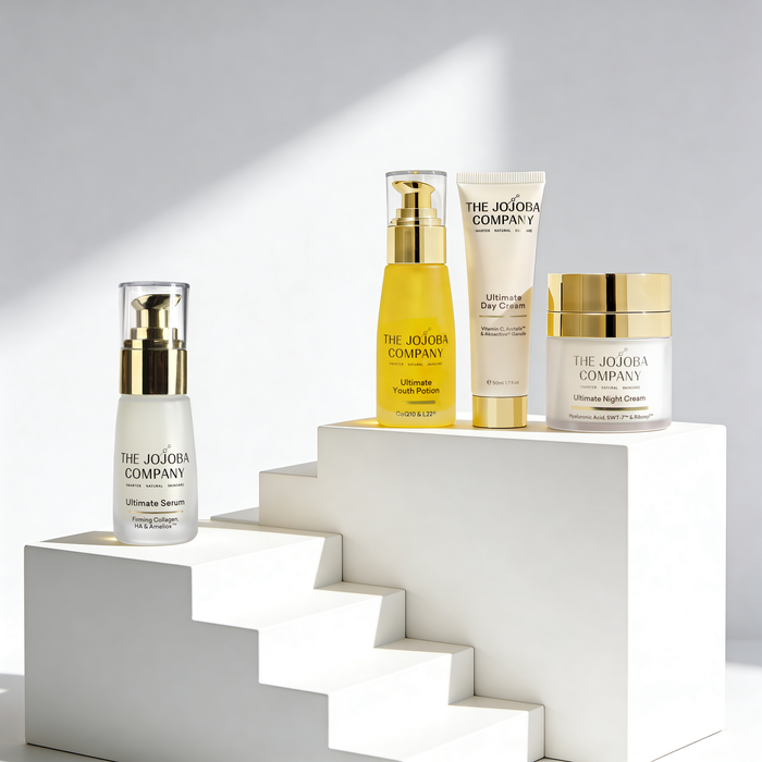 Skincare products from The Jojoba Company on a white geometric structure