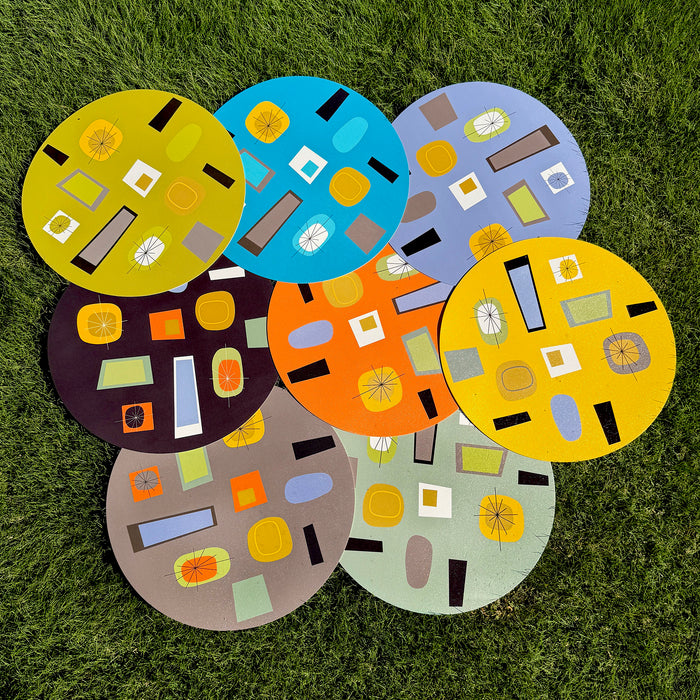 Set of colorful round rugs with abstract patterns on a grassy background