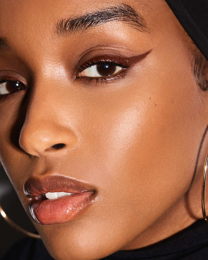 model with winged eyeliner look using Fenty Beauty Flyliner Longwear Liquid Eyeliner in shade In Big Truffle