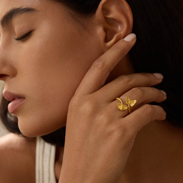 A close-up of a woman's hand showcasing the Freedom to Soar Adjustable Butterfly Ring, symbolizing freedom and transformation. This stunning piece of spiritual jewelry serves as a meditation talisman that connects with the energy of the sun and moon, perfect for meaningful practices and manifestation.