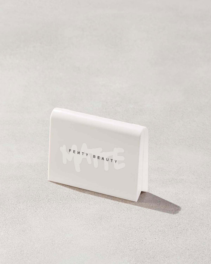 Invisimatte Instant Setting + Blotting Powder with closed packaging shown on a concrete background.