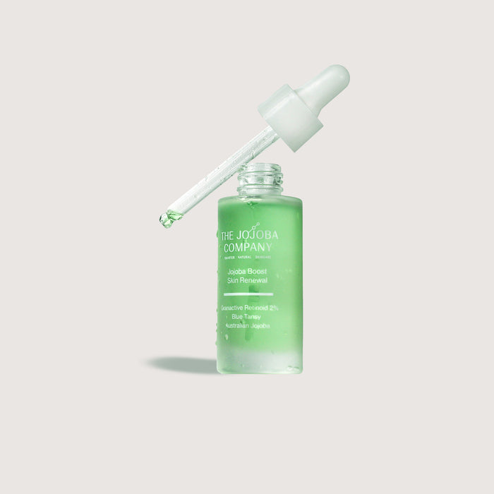 Skincare dropper bottle with green liquid on a light gray background Jojoba Boost Skin Renewal