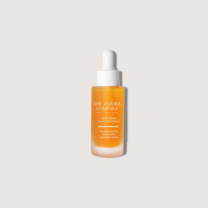 Skincare serum bottle with 'The Jojoba Company' branding and product featured Jojoba Boost Super Antioxidant on a light gray background