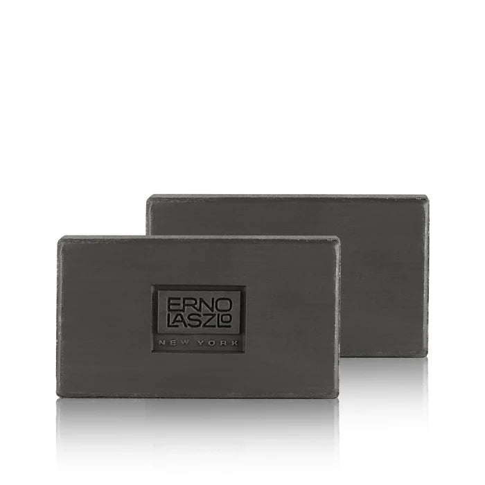 Two dark gray rectangular bars of soap stacked slightly offset, with the front bar embossed with the brand name 'ERNO LASZLO NEW YORK' on a clean white background.